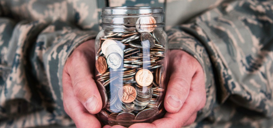 US military serviceman holding jar full of coins ©iStockphoto.com/Catherine Lane